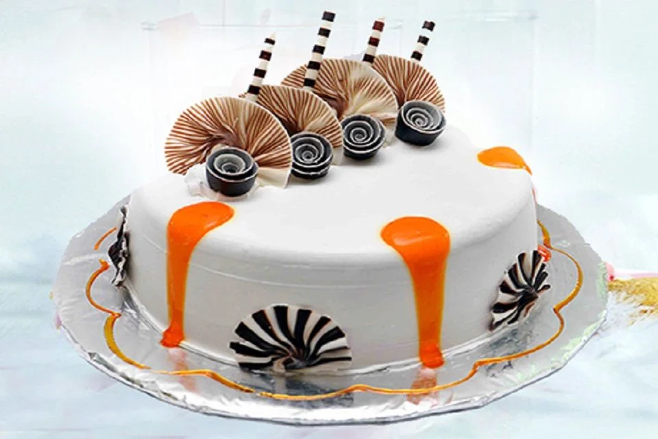 Mẫu bánh sinh nhật phủ kem trắng trang trí chocolate cuộn và sốt cam