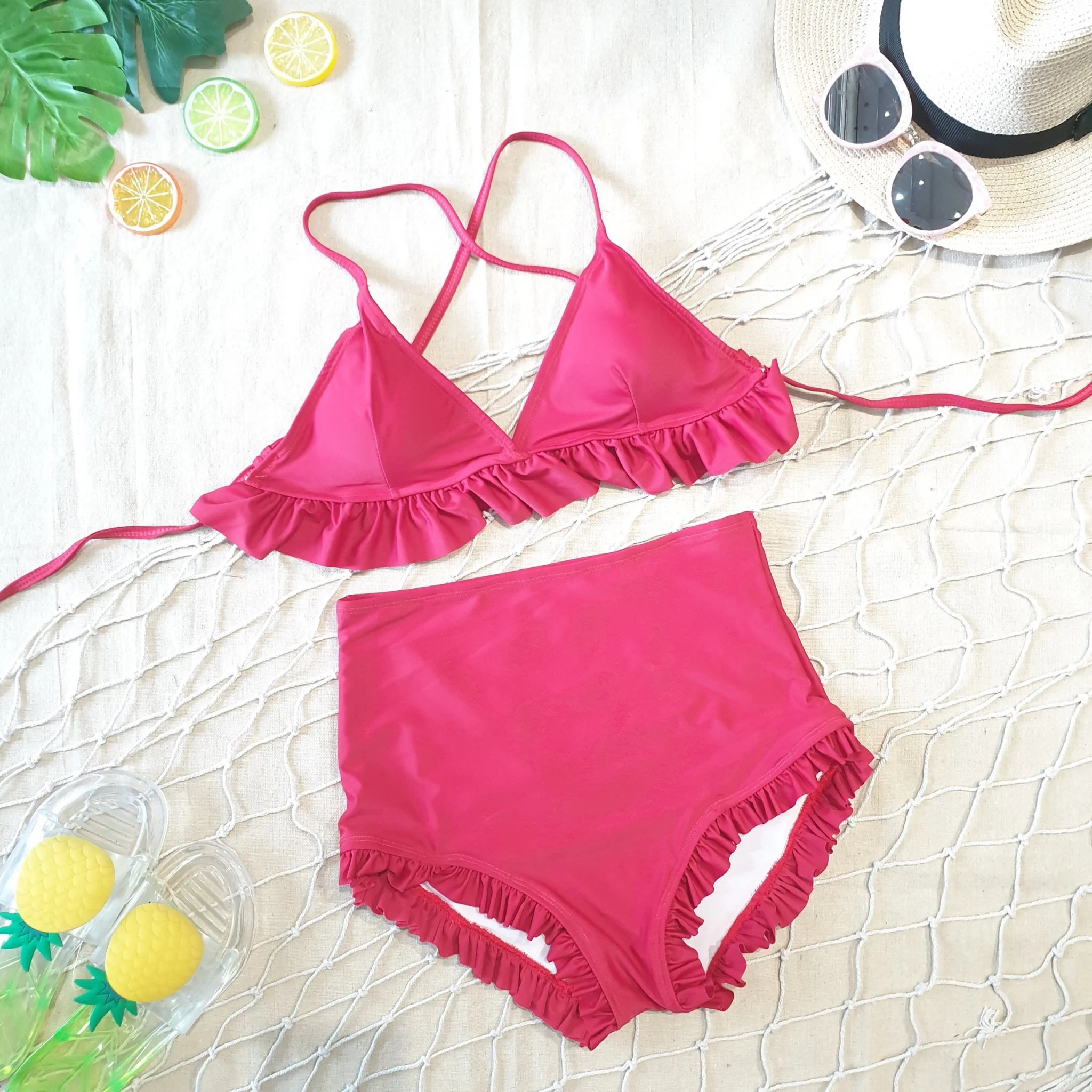 Bikini hai mảnh màu hồng đặt trên lưới cùng phụ kiện mùa hè