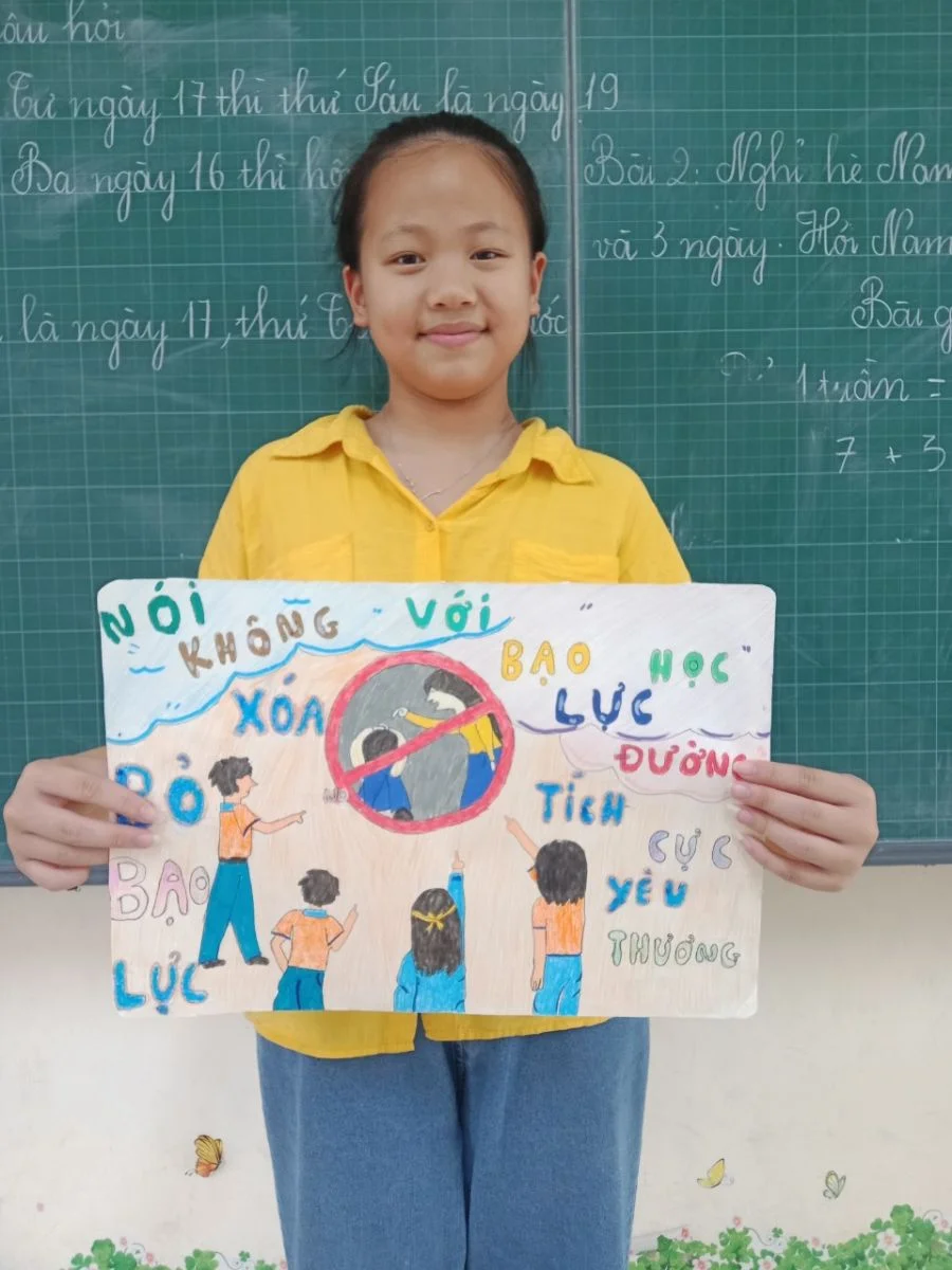 Học sinh cầm tranh vẽ cổ động phòng chống bạo lực học đường