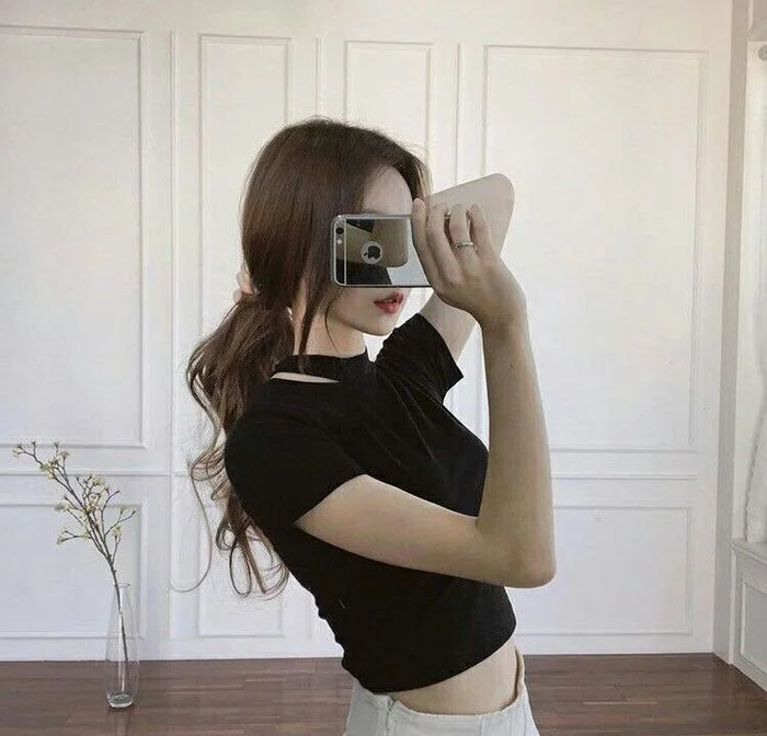 Cô gái mặc áo đen chụp gương che mặt